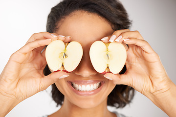 Image showing Happy woman, apple and eyes for diet, nutrition or health and wellness against a gray studio background. Portrait of female person or nutritionist smile with organic fruit slices for vitamin or fiber