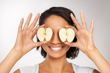 Image showing Happy woman, apple and eyes for natural nutrition, diet or health and wellness against a gray studio background. Portrait of female person or nutritionist smile with organic fruit slices for vitamins
