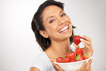 Image showing Health, strawberries and young woman in a studio for wellness, nutrition and organic diet. Smile, vitamins and portrait of female person eating a fruit for healthy vegan snack by gray background.