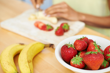 Image showing Woman, hands and cutting fruit in kitchen for diet, healthy meal or preparing salad or smoothie at home. Closeup of female person or vegetarian slicing banana and strawberry for natural nutrition