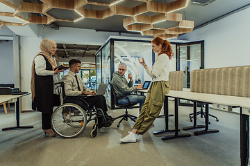 Image showing Young group of business people brainstorming together in a startup space, discussing business projects, investments, and solving challenges.