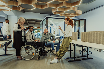 Image showing Young group of business people brainstorming together in a startup space, discussing business projects, investments, and solving challenges.