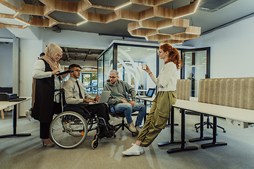 Image showing Young group of business people brainstorming together in a startup space, discussing business projects, investments, and solving challenges.