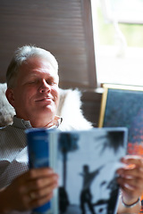 Image showing Relax, magazine or senior man reading newspaper articles in home for information or story updates. Smile, book or mature person studying abstract art for knowledge in a publication in living room