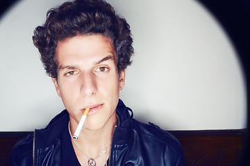 Image showing Portrait of man with cigarette, punk fashion and rockstar attitude on white background with spotlight. Cool rock style, modern creative and smoking, confident face of handsome male model in studio.