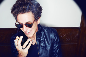 Image showing Man with cigarette, rock fashion and smile with rockstar attitude on white background in spotlight. Cool punk style, grunge and smoking, confident and happy male model in studio with sunglasses.