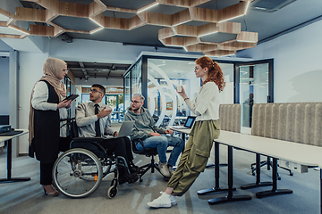 Image showing Young group of business people brainstorming together in a startup space, discussing business projects, investments, and solving challenges.