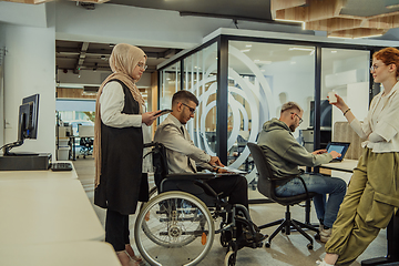 Image showing Young group of business people brainstorming together in a startup space, discussing business projects, investments, and solving challenges.