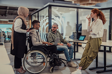 Image showing Young group of business people brainstorming together in a startup space, discussing business projects, investments, and solving challenges.