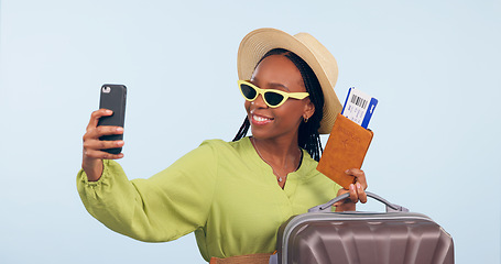 Image showing Black woman, selfie with suitcase and passport for travel, vacation and social media post on blue background. Luggage, smile in picture with plane ticket and booking documents for adventure in studio