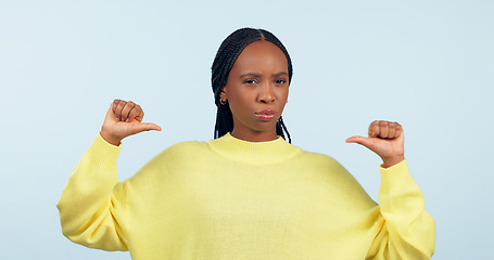 Image showing Portrait, attitude and a pointing black woman with confidence in studio on a gray background. Face, frown and expression with a young person looking serious about her fashion or style choice