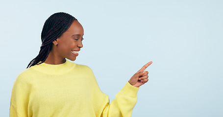 Image showing Pointing, smile and black woman with opportunity, decision and announcement on a blue studio background. African person, model and girl with hand gesture, mockup space and choice with news or sale