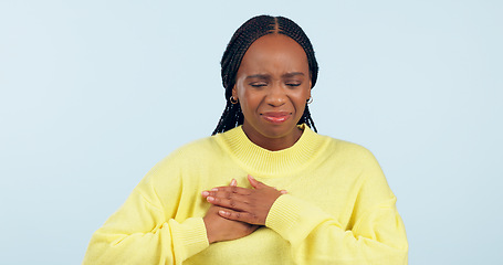 Image showing Woman, sick and pain in studio for heart attack, medical crisis and cardiovascular healthcare on blue background. African model, emergency and chest with acid reflux, stroke and help for hypertension