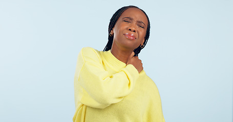 Image showing Neck, pain and injury of woman in studio with stress, risk of arthritis and tired joints on blue background. African model massage spine muscle for first aid, health emergency and crisis of fatigue