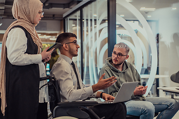 Image showing Young group of business people brainstorming together in a startup space, discussing business projects, investments, and solving challenges.