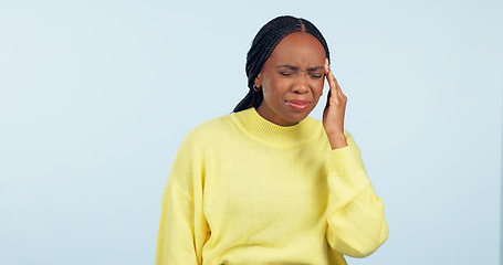Image showing Woman, pain and headache in studio for stress, challenge and fatigue of mental health on blue background. African model massage temple for anxiety, brain fog or tired of migraine, vertigo and burnout