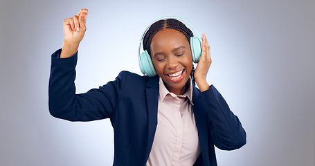 Image showing Dance, headphones and business woman in studio for celebration, freedom and excited for winning on grey background. Happy african worker listening to music, audio or streaming radio sound with energy