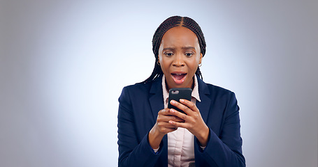 Image showing Wow, phone and confused black woman with omg face in studio with fake news, review or feedback on grey background. Surprise, anxiety and African entrepreneur shocked by social media, hacker or spam