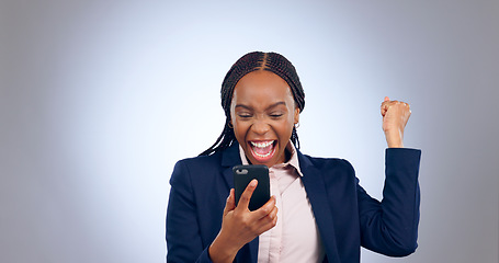 Image showing Business woman, winning and phone in studio for success, celebrate profit and bonus promotion on grey background. Excited african worker, achievement and fist for mobile deal, news of reward or prize