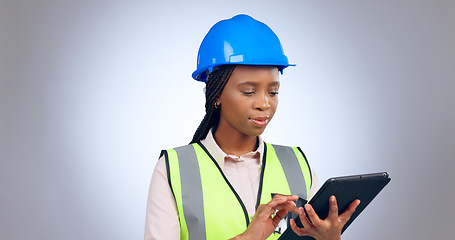 Image showing Black woman, engineer and typing on tablet in studio isolated on white background mockup space. Technology, architect and research on internet, digital app or planning construction for communication