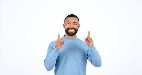 Image showing Happy, face and man with hand pointing up in studio for announcement, info or promo on white background. Smile, portrait and excited male model show giveaway, deal or lottery competition prize offer