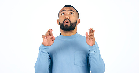 Image showing Man, fingers crossed for win, thinking and good luck for announcement, deal and news. Optimistic, hope and achievement in competition, success and white background for worry, nervous and wish