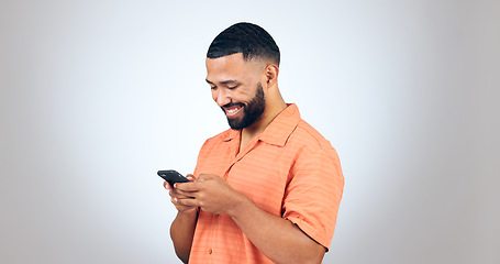 Image showing Phone, chat and happy man laugh in studio with online comic, meme or funny text on grey background. Smartphone, smile or male model with app joke, humor and contact or web, network or communication