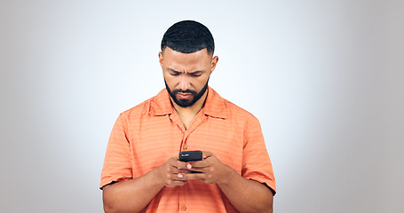 Image showing Confused, text and man in studio reading fake news, email or error notification on grey background. Doubt, smartphone and male model with with app password glitch, 404 or phishing, scam or review