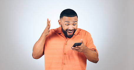 Image showing Man, smartphone and surprise, giveaway winner and celebrate with reaction on white background. Social media, communication and wow, reward or bonus online with email notification and shock in studio