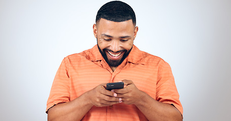 Image showing Man in studio with phone, smile and typing with connection for networking, online chat or communication. Good news, notification and happy person writing message, email or post on white background.