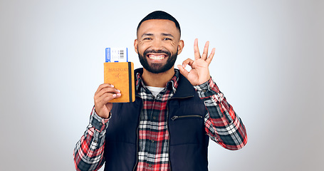 Image showing Ok sign, portrait and man with a passport, smile and vacation on white studio background. Face, model and tourist with tickets, perfect symbol and travelling with mockup space, agreement and holiday