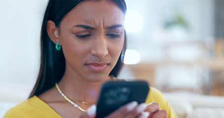 Image showing Confused, doubt and woman networking on a phone on sofa in the living room reading bad news. Upset, mad and young Indian female person scroll on social media or the internet with cellphone at home.