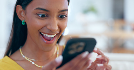 Image showing Surprise, happy and woman networking on a phone on sofa in the living room reading gossip. Excited, shock and young Indian female person scroll on social media or the internet with cellphone at home.