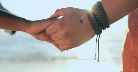 Image showing Love, zoom and couple holding hands at a beach with respect, gratitude and trust in nature together. Commitment, closeup and people together at sea with support, kindness and summer travel freedom