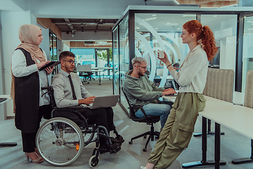 Image showing Young group of business people brainstorming together in a startup space, discussing business projects, investments, and solving challenges.