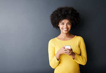 Image showing Social media, chat and portrait of black woman using phone or smile in studio, mockup and grey background. Cellphone, app or person typing contact or internet communication on website with happiness