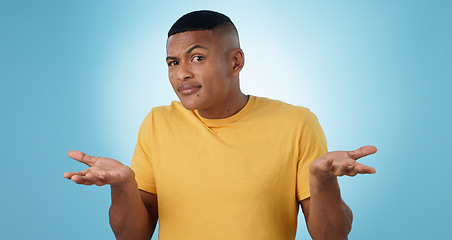 Image showing Confused, shrug and portrait of man in studio with why hands on blue background space. Doubt, face and model with dont know emoji for choice, decision or palm scale, questions or asking body language