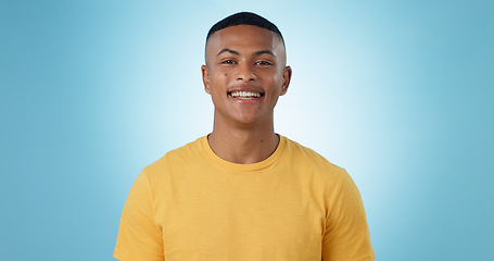 Image showing Portrait, young man and smile in studio with confidence, good mood or casual fashion isolated on blue background. Happy gen z model with cheerful personality, pride and mockup space in Puerto Rico