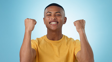 Image showing Man, portrait and excited for success with fist in studio to celebrate deal, promotion or yes to winning lottery on blue background. Happy model, giveaway prize winner or reward for bonus achievement