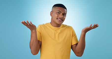 Image showing Confused, shrug and man portrait in studio with why hands on blue background space. Doubt, face and model with dont know emoji for choice, decision or palm scale, questions or asking body language