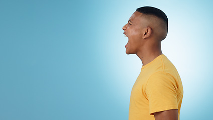Image showing Angry, man and scream in studio at mockup space for crisis, anger or mad emoji reaction on blue background. Profile of frustrated model shouting with stress, emotional conflict or negative expression