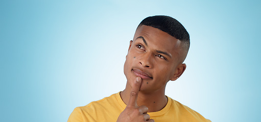 Image showing Man, face and thinking in planning, decision or choice for idea or memory against a blue studio background. Unsure male person or curious model in wonder, remember or solution in why, emoji or mockup