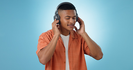 Image showing Music, man and dancing with headphones and studio with radio and audio app with blue background. Tech, smile and sound with relax African male person with web media streaming and hearing a song