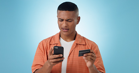 Image showing Man, credit card and phone in studio, frustrated face or confused with thinking, fintech and blue background. Person, smartphone and online shopping with glitch, payment decline and fail with banking