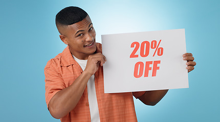 Image showing Portrait, man and poster for sale in studio with mock up for discount on blue background. Cape Town, male model and smile with announcement, promotion and sign on board with presentation in space