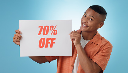 Image showing Portrait, happy man and board with sale in studio on blue background for mock up with discount, promo or offer. Cape Town, model or person with poster, notification or announcement for deal in space