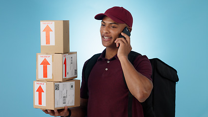 Image showing Delivery man, boxes and phone call for courier communication, e commerce information and update on package. Worker or logistics supplier mobile chat for customer service on a blue, studio background