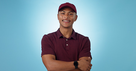 Image showing Delivery man, arms crossed or portrait for distribution or mockup space on blue background. Professional, retail supply chain or happy logistics worker for shipping or courier service in studio