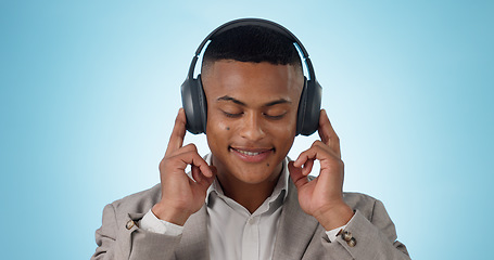 Image showing Music, business man and calm with headphones and studio with radio and audio app with blue background. Tech, smile and sound with relax African male person with web media streaming and hearing a song