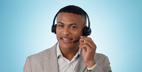 Image showing Call center, man and portrait in studio for customer service, CRM questions and IT support on blue background. Face of telemarketing salesman, virtual consultant and microphone for telecom advisory